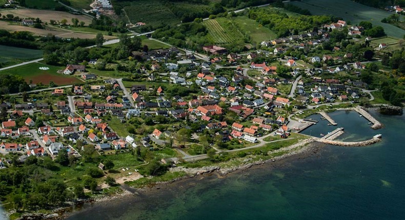 Flygbild över Baskemölla. På bilden syns husen, många med röda tegeltak, kusten med havet utanför och hamnen.