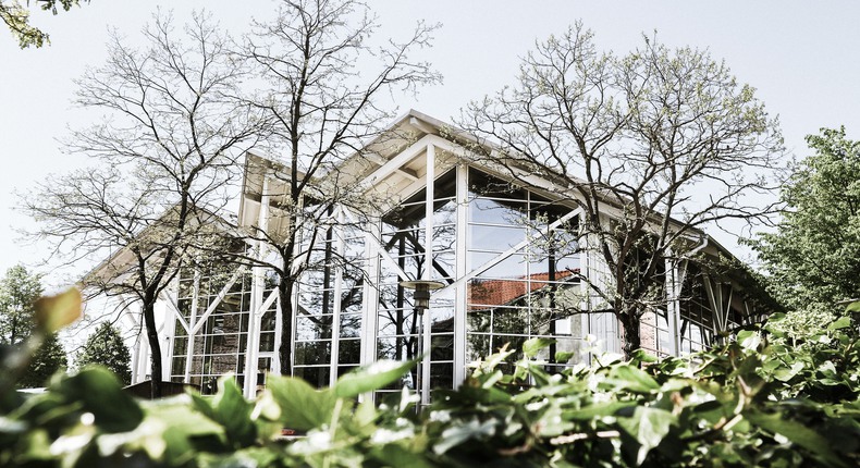 Simrishamns biblioteks exteriör med sågtandat tak och stora glaspartier istället för väggar. Murgröna i förgrunden.