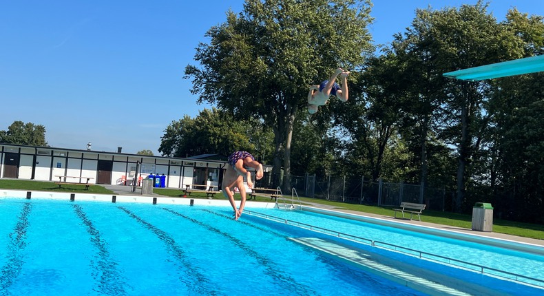 Hammenhögs friluftsbad med sin 25- metersbassäng och två trampoliner, varifrån två barn hoppar.