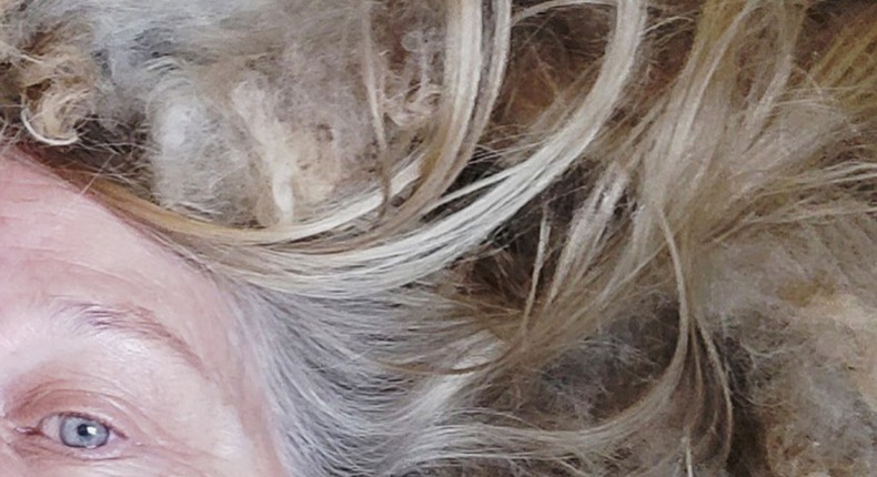 En kvinna tar en selfie där bara hennes ena blå öga syns, hennes hår blandas med ull.